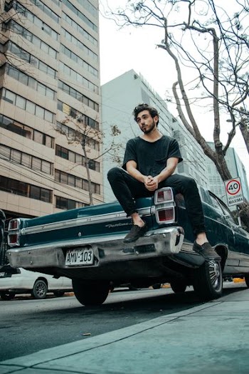 man sitting on classic car