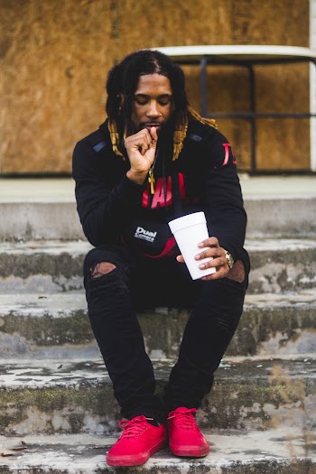 Man Sitting on Concrete Stairs Staring on Plastic Cup