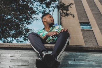 Man Sitting on Concrete Wall