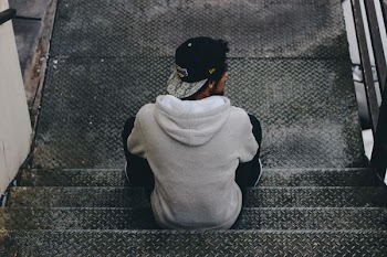 man sitting on diamond plated metal stairs