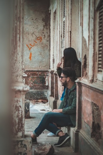 Man Sitting on Door Next to Woman
