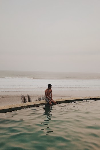 Man Sitting on Edge of Pool