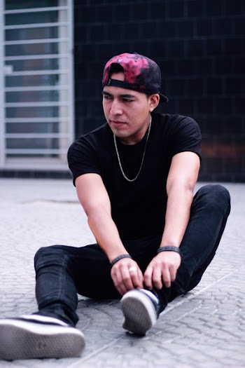 Man Sitting on Floor While Touching His Shoe Lace