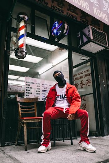 man sitting on front of barber shop