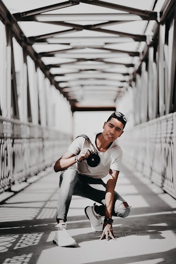 Man Sitting on Gray Bridge