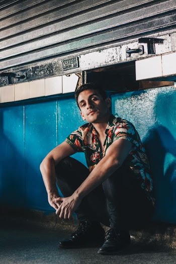 man sitting on ground leaning on wall