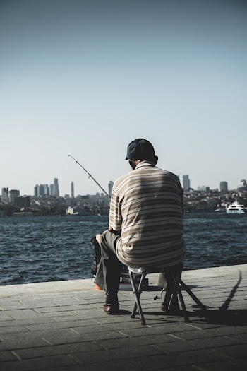 Man Sitting on Holding Fishing Rod