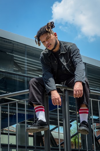 Man Sitting on Metal Handrail