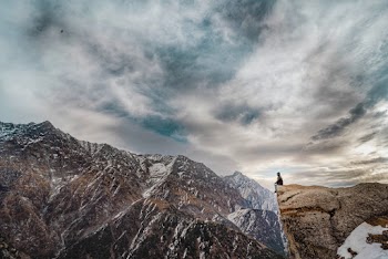Man Sitting on Mountain Peak