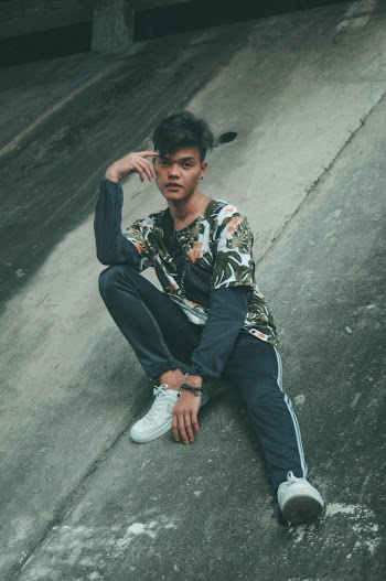 Man Sitting on Pavement