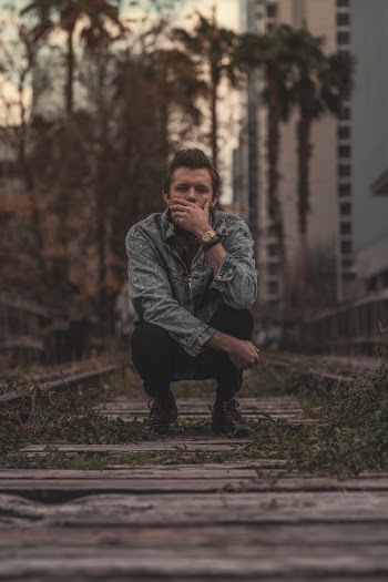 Man Sitting on Railroad