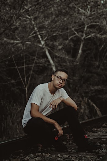 Man Sitting on Railroad Track