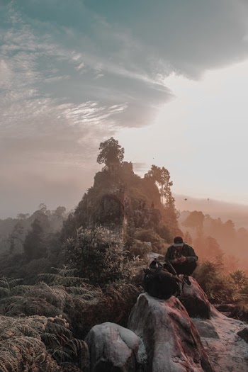 Man Sitting On Rock