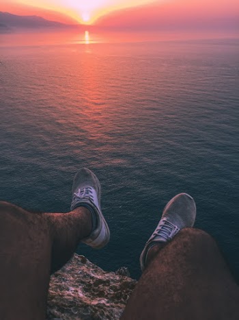 Man Sitting on Rock Cliff during Golden Hour