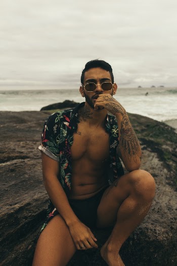 Man Sitting on Rock Near Ocean