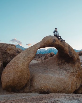 man sitting on rock structure