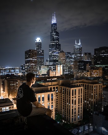 Man Sitting On Rooftop At Night
