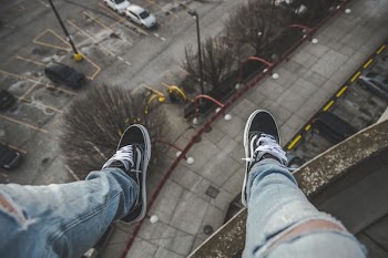 man sitting on rooftop selective focus photography