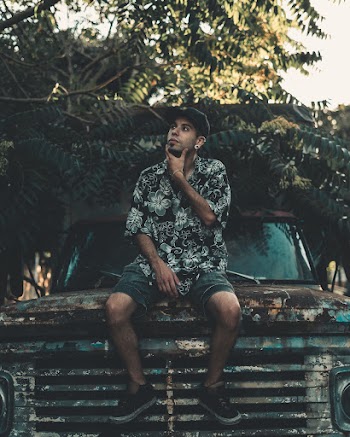 Man Sitting On Rusty Vehicle