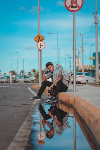 Man Sitting On Sidewalk