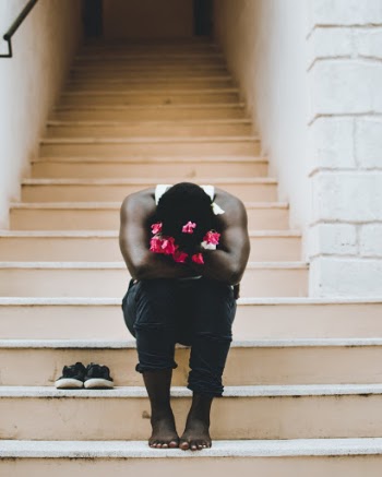 Man Sitting on Stair Wearing White Tank Top and Black Jeans