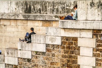 man sitting on staircase behind woman sitting on highest staircase