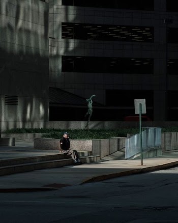 man sitting on stairs outside building