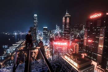 Man Sitting on Steel Fence