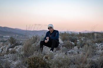 Man Sitting on Stone Near Green Grass