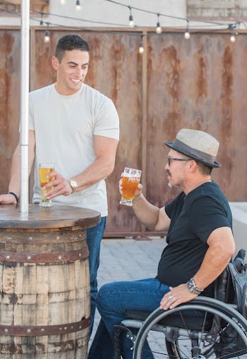 Man Sitting on the Wheelchair Holding Glass With Beer
