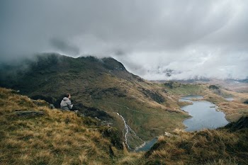 man sitting on top of mountain