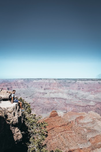 Man Sitting on Top of Rock Mountain