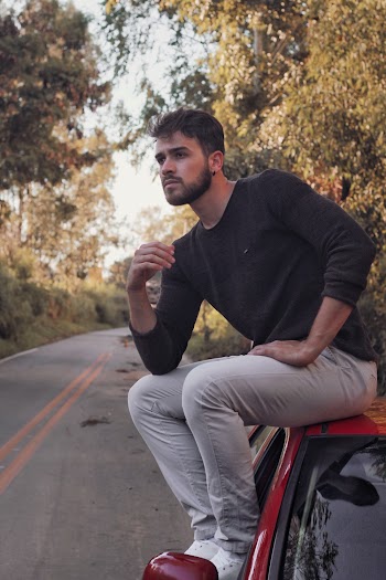 Man Sitting On Top Of Vehicle