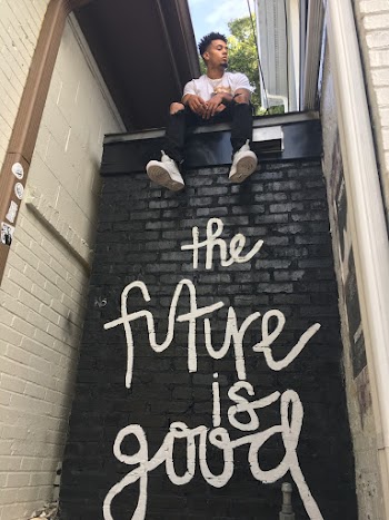 Man Sitting on Top of Wall With the Future Is Good Print