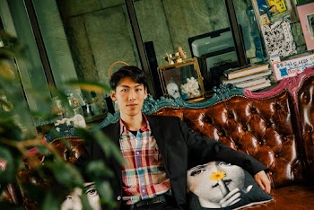 Man Sitting on Tufted Brown Leather Chesterfield Sofa
