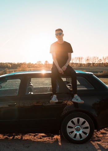 Man Sitting On Vehicle Roof