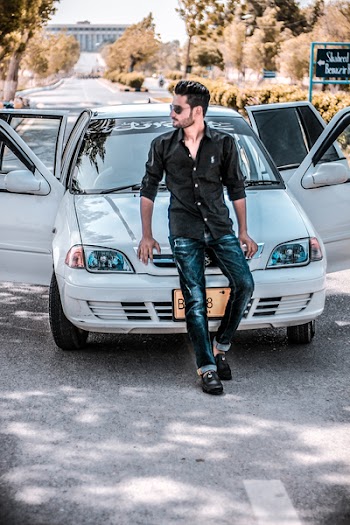 Man Sitting on White Car Hood