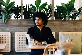 man sitting on white chair while looking sideways