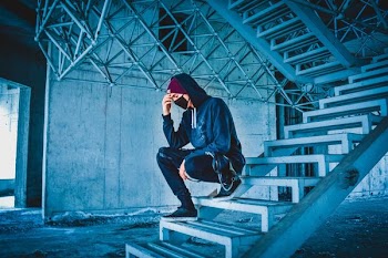 man sitting on white concrete stairs