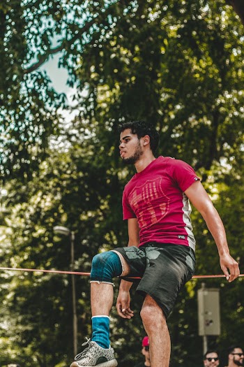 Man Sitting on Wire by Tree