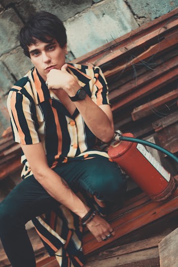 Man Sitting on Wooden Planks Posing