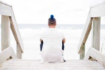 man sitting on wooden staircase