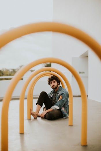 Man Sitting on Yellow Arch Outdoor