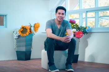 Man Sitting oO White Ottoman In Room