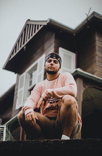Man Sitting Outside A Wooden House