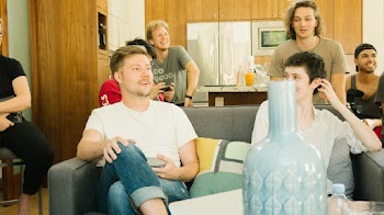 Man Sitting Wearing White Crew-neck T-shirt Inside Room