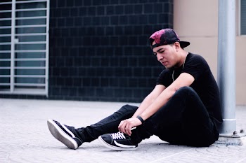 Man Sitting While Fixing His Black Jeans