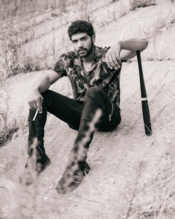 Man Sitting While Holding a Cigarette