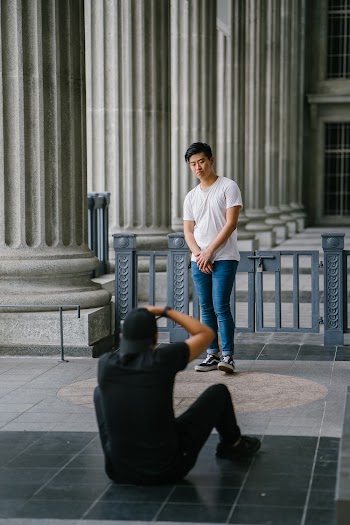 Man Sitting While Taking Picture Of Another Man 