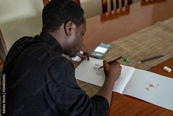 man sketching at a table 